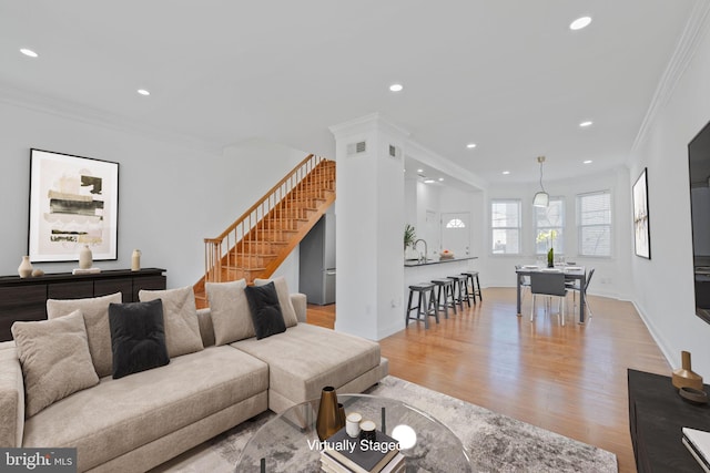 living area featuring recessed lighting, stairway, wood finished floors, and crown molding