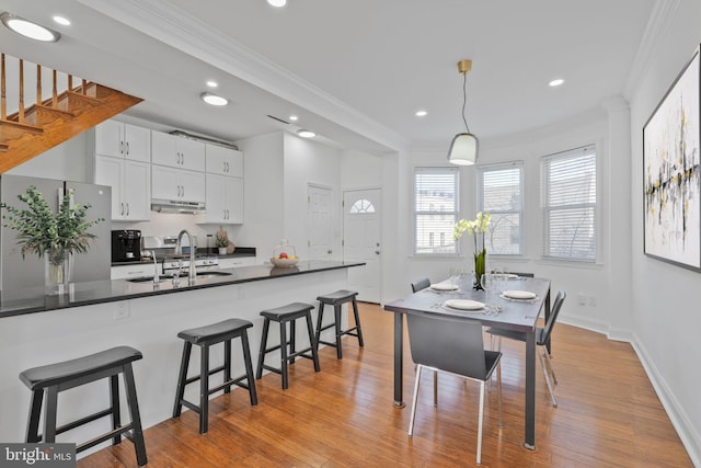 dining area featuring recessed lighting, light wood-style floors, and ornamental molding