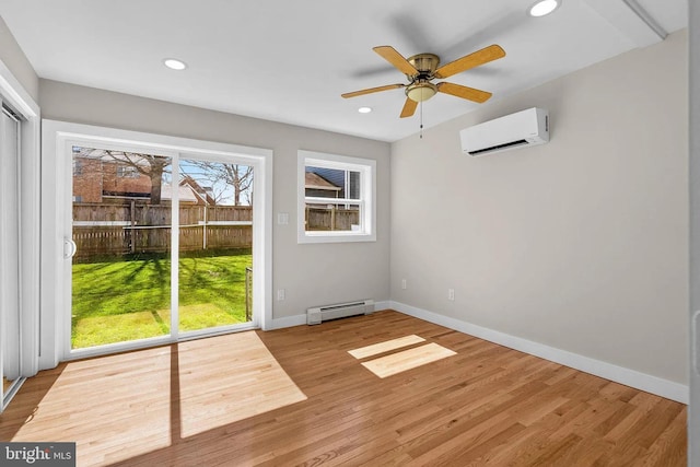 interior space featuring a wall unit AC, wood finished floors, baseboards, a baseboard radiator, and recessed lighting