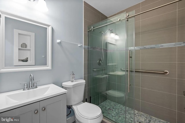 full bathroom with a shower stall, toilet, and vanity