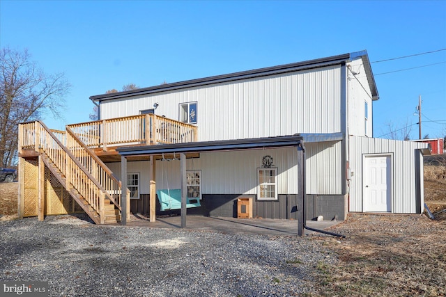 back of house featuring stairway and a wooden deck