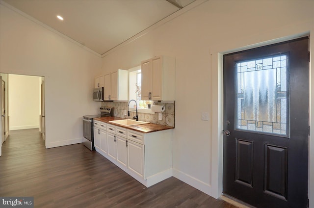 kitchen with tasteful backsplash, dark wood finished floors, appliances with stainless steel finishes, white cabinetry, and a sink