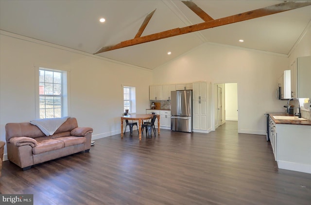 living area with plenty of natural light, high vaulted ceiling, baseboards, and dark wood-style flooring