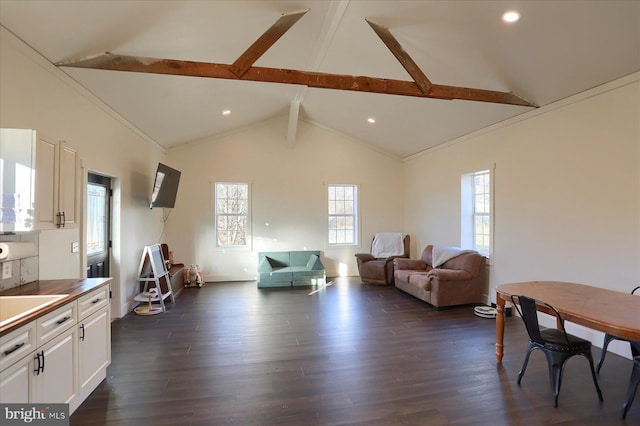 living area with beam ceiling, high vaulted ceiling, dark wood-style floors, and a healthy amount of sunlight