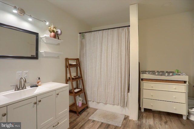 bathroom featuring vanity, toilet, wood finished floors, and shower / bath combo