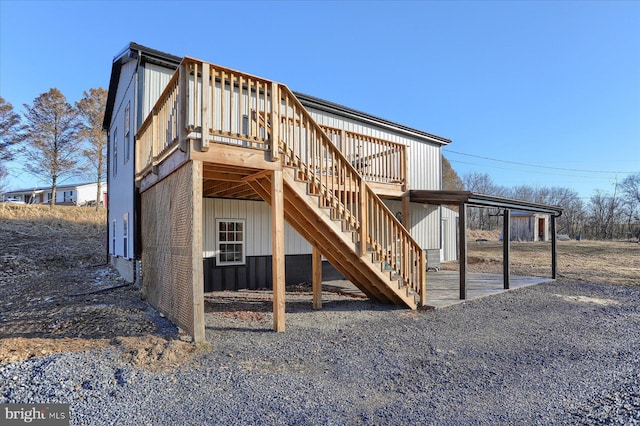 back of property with a deck and stairway