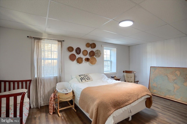 bedroom featuring wood finished floors and a drop ceiling