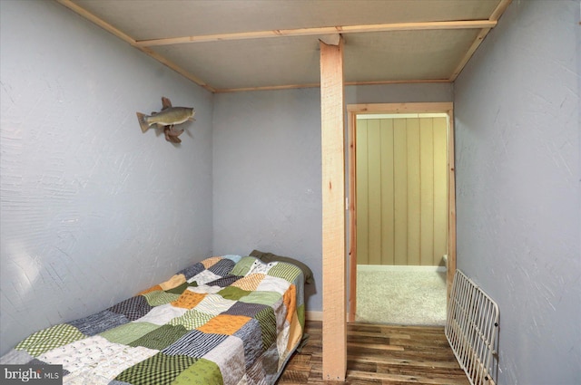 bedroom featuring a textured wall and wood finished floors