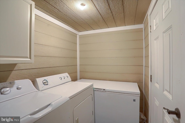 laundry area featuring cabinet space, independent washer and dryer, wooden ceiling, and wood walls