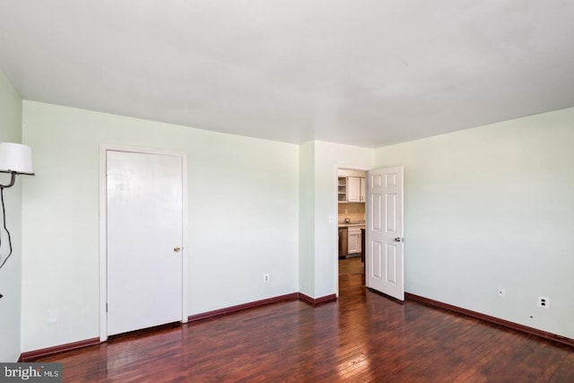 unfurnished bedroom with hardwood / wood-style flooring and baseboards