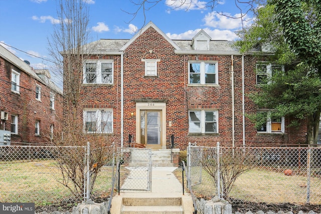 view of front of property with a gate, brick siding, and a fenced front yard