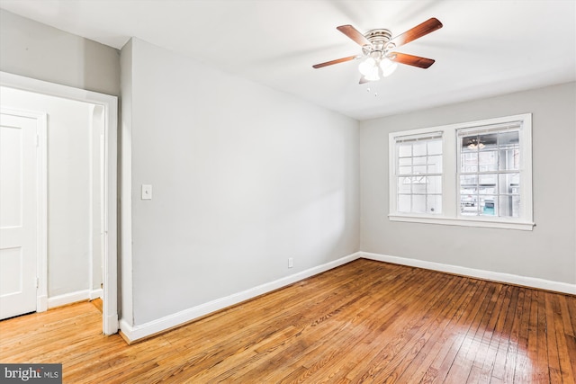 empty room with baseboards, a ceiling fan, and light wood finished floors