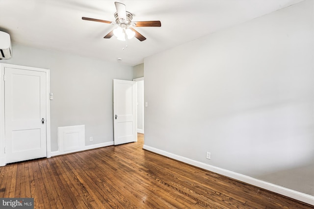 unfurnished bedroom with an AC wall unit, a ceiling fan, baseboards, and wood-type flooring