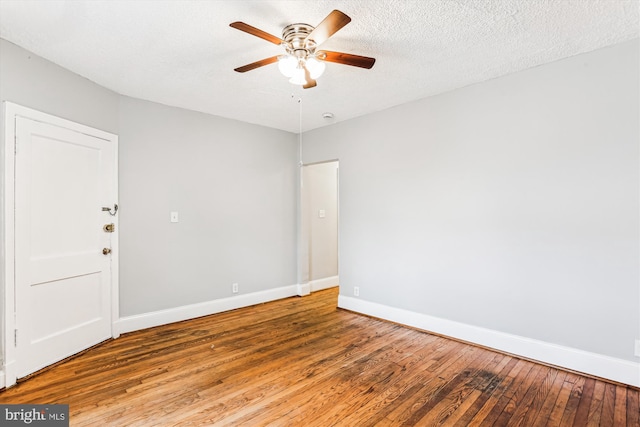 unfurnished room with a textured ceiling, a ceiling fan, baseboards, and hardwood / wood-style flooring