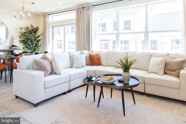 living room featuring recessed lighting, a notable chandelier, and light wood finished floors