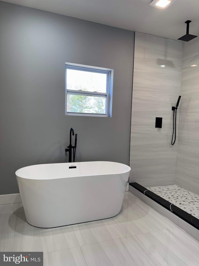 full bathroom featuring a freestanding tub and a tile shower