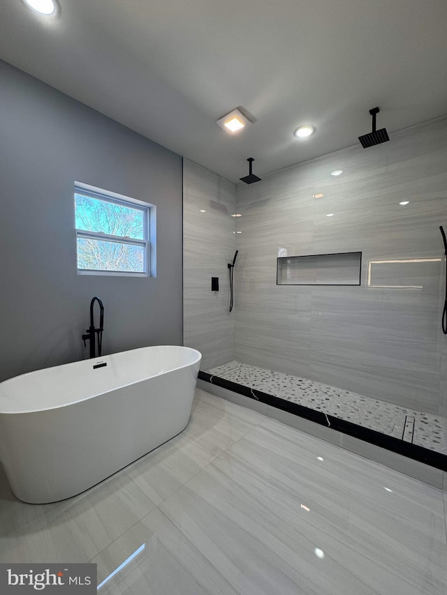 bathroom with a freestanding tub and a tile shower