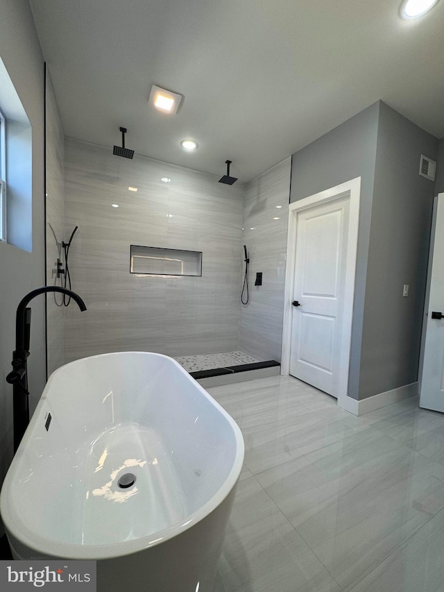 full bathroom with baseboards, visible vents, recessed lighting, a freestanding bath, and walk in shower