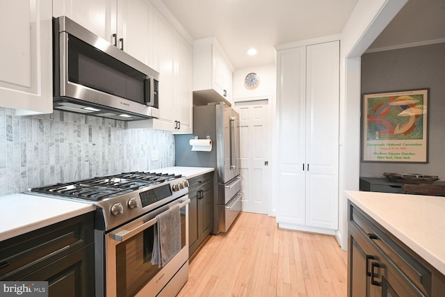 kitchen with white cabinets, stainless steel appliances, light wood-style floors, and light countertops