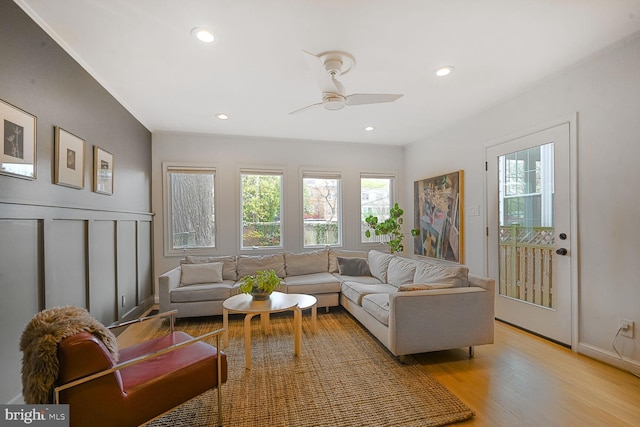 living room featuring light wood-type flooring, recessed lighting, a ceiling fan, and plenty of natural light