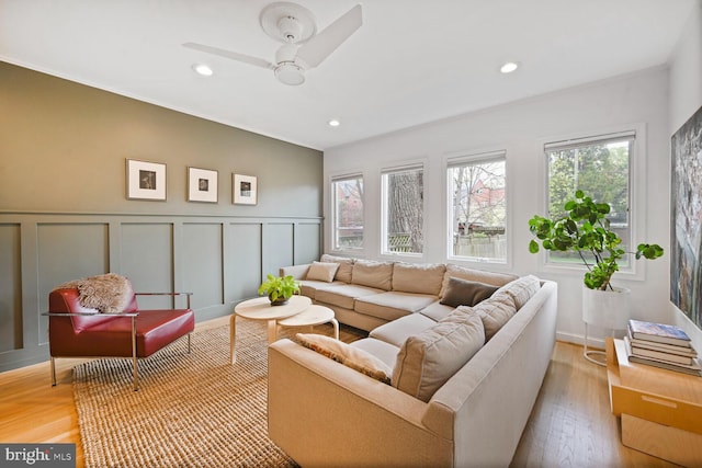 living room featuring recessed lighting, light wood-style flooring, a decorative wall, a wainscoted wall, and ceiling fan