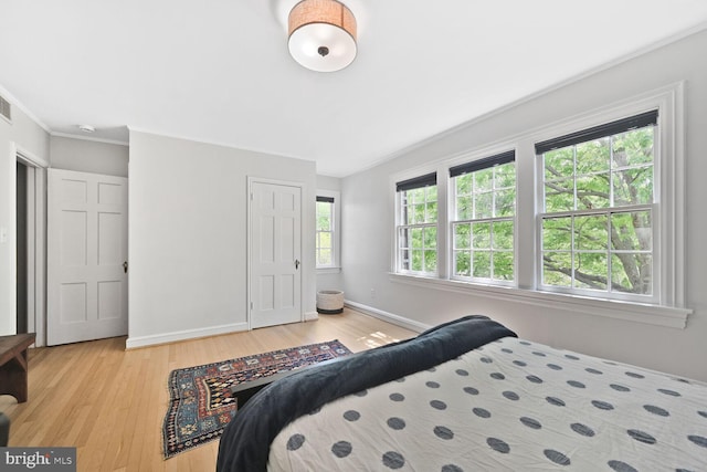 bedroom featuring baseboards, visible vents, and light wood-style flooring