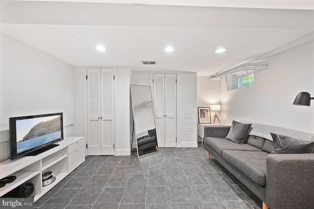 living room with dark tile patterned floors, visible vents, baseboards, and recessed lighting