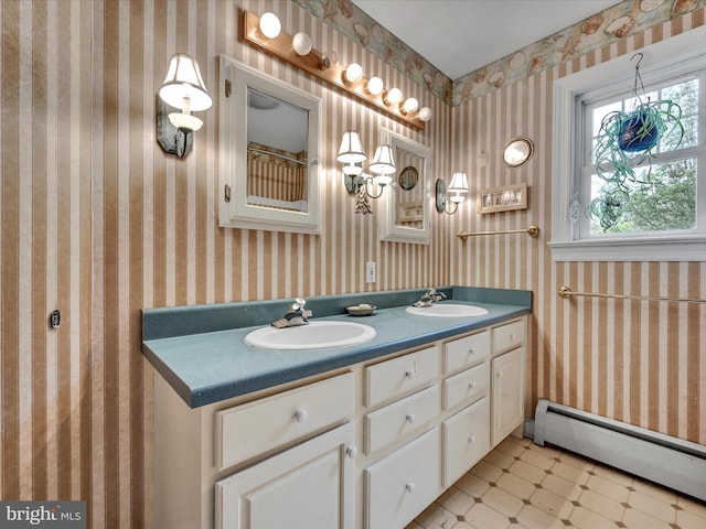 bathroom with tile patterned floors, a sink, wallpapered walls, double vanity, and a baseboard radiator