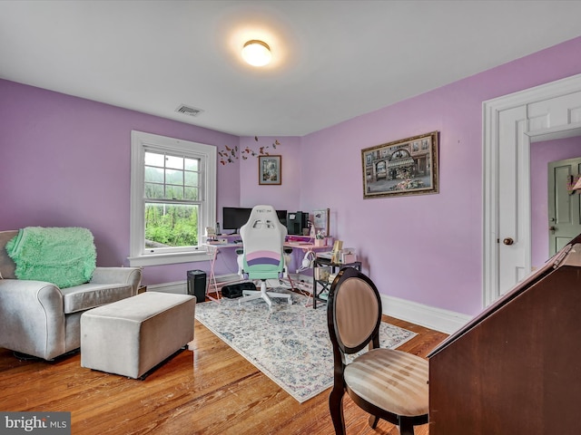 interior space with visible vents, baseboards, and wood finished floors