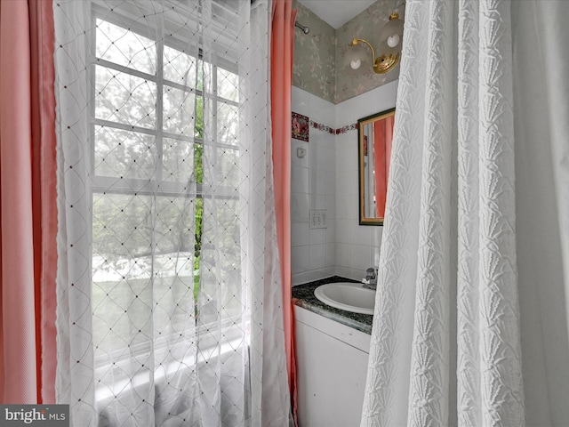 bathroom with vanity and tile walls