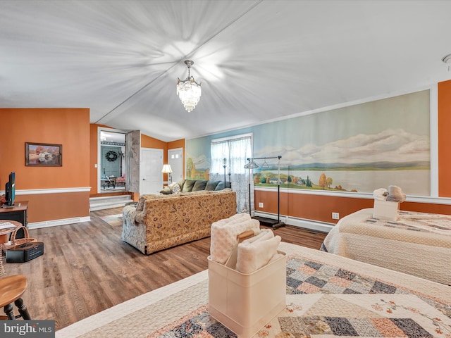 bedroom with wood finished floors, baseboards, vaulted ceiling, a baseboard heating unit, and a notable chandelier