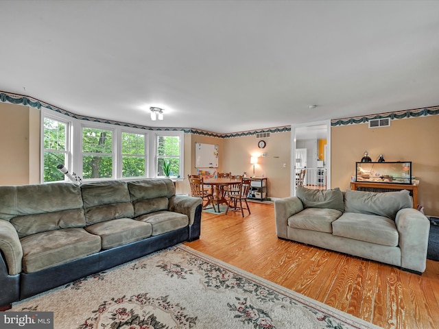 living room featuring visible vents and wood finished floors