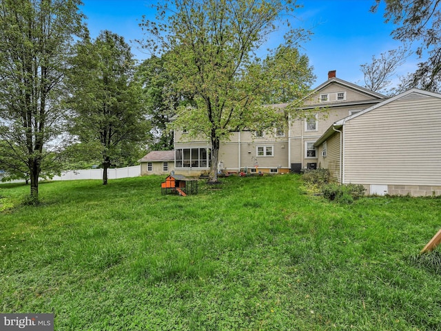 view of yard featuring a sunroom and fence