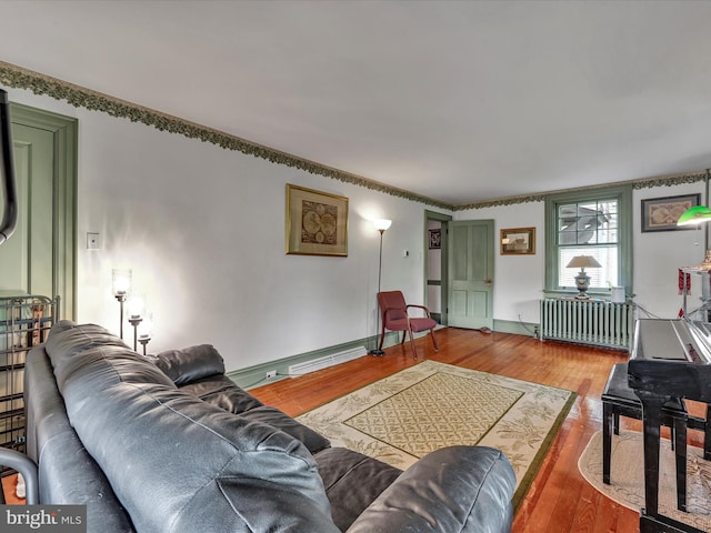 living room featuring radiator, wood finished floors, baseboards, and baseboard heating