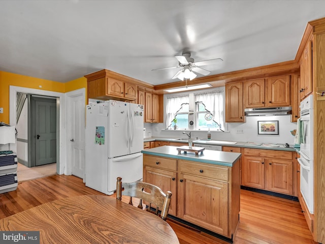 kitchen with a center island, ceiling fan, under cabinet range hood, light wood-style floors, and white appliances