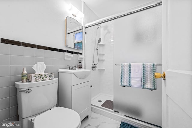 bathroom with vanity, a shower stall, tile walls, toilet, and marble finish floor