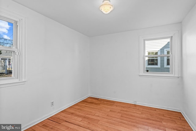 empty room featuring light wood-type flooring and baseboards