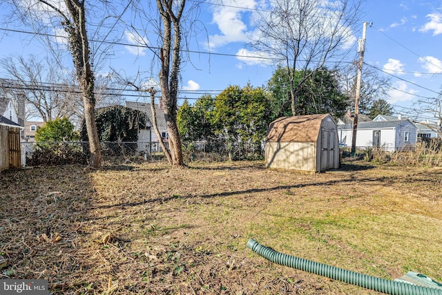 view of yard with a storage shed, a fenced backyard, and an outdoor structure