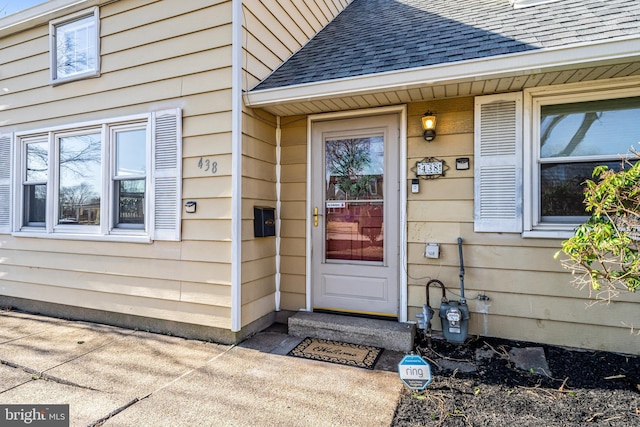 property entrance featuring roof with shingles