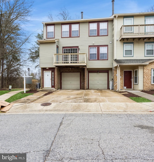 multi unit property featuring brick siding, central AC unit, a garage, and driveway