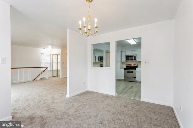 empty room with baseboards, light carpet, and a chandelier