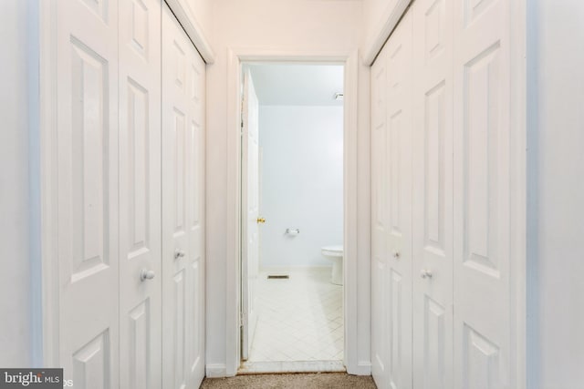 hallway featuring baseboards and carpet floors