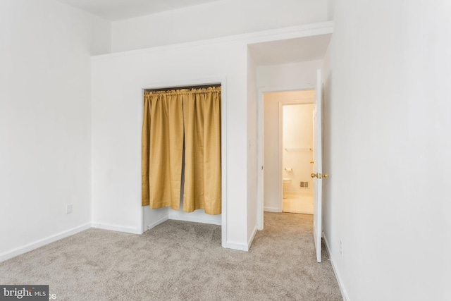 unfurnished bedroom with a closet, baseboards, and carpet flooring