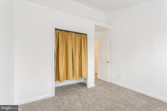 unfurnished bedroom featuring carpet flooring and baseboards