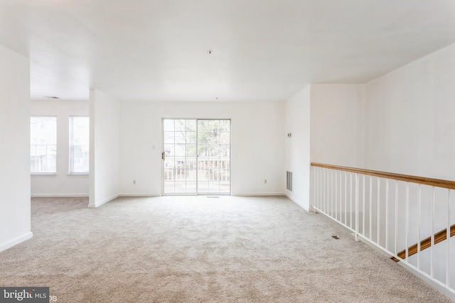 unfurnished room featuring visible vents, baseboards, and carpet floors