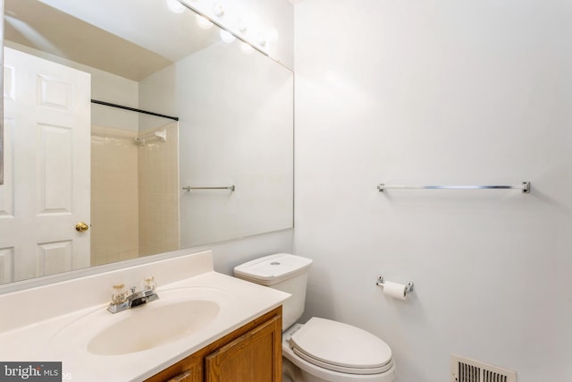 bathroom with vanity, toilet, a shower, and visible vents