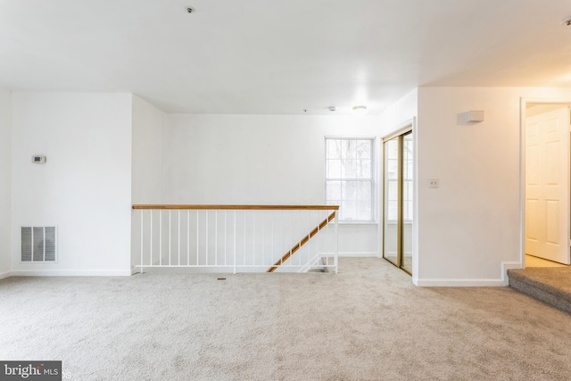 carpeted empty room with visible vents and baseboards