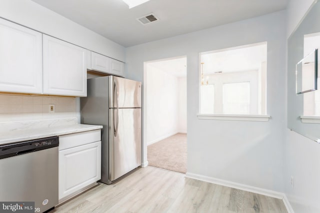 kitchen featuring visible vents, backsplash, appliances with stainless steel finishes, and white cabinets