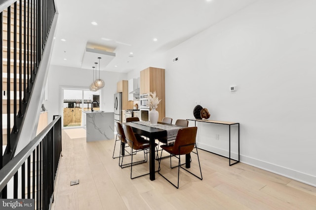 dining area featuring visible vents, recessed lighting, stairway, light wood finished floors, and baseboards