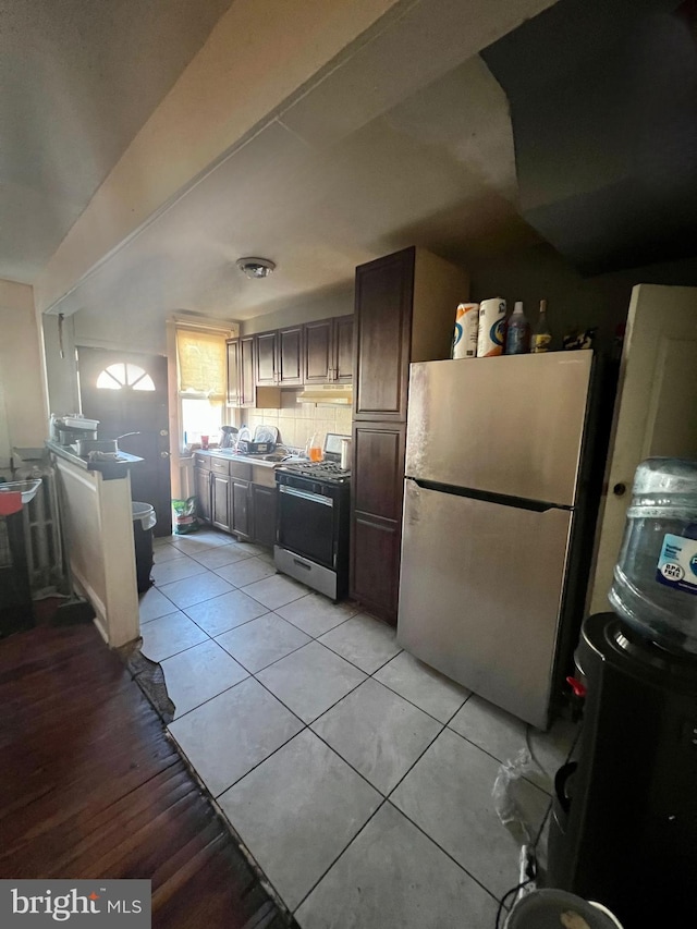 kitchen featuring light tile patterned flooring, tasteful backsplash, and appliances with stainless steel finishes